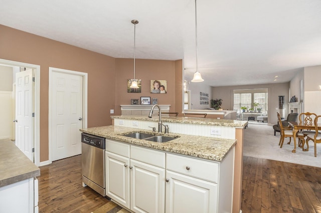 kitchen with sink, hanging light fixtures, a center island with sink, stainless steel dishwasher, and white cabinets