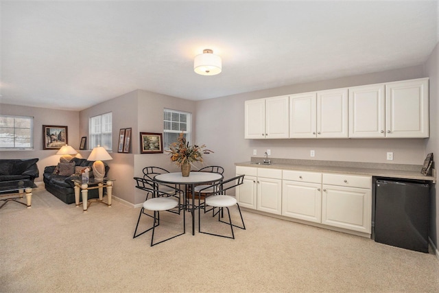 dining space featuring light carpet and wet bar