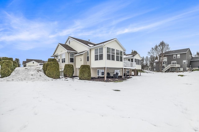 snow covered property with a sunroom and a deck