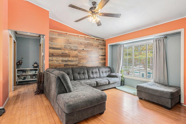 living room featuring lofted ceiling, wood-type flooring, wooden walls, and ceiling fan