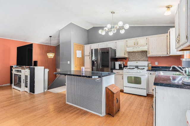 kitchen featuring decorative light fixtures, sink, a center island, white range with gas cooktop, and stainless steel refrigerator with ice dispenser