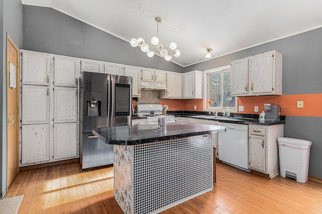 kitchen featuring vaulted ceiling, a kitchen island, sink, light hardwood / wood-style floors, and white appliances