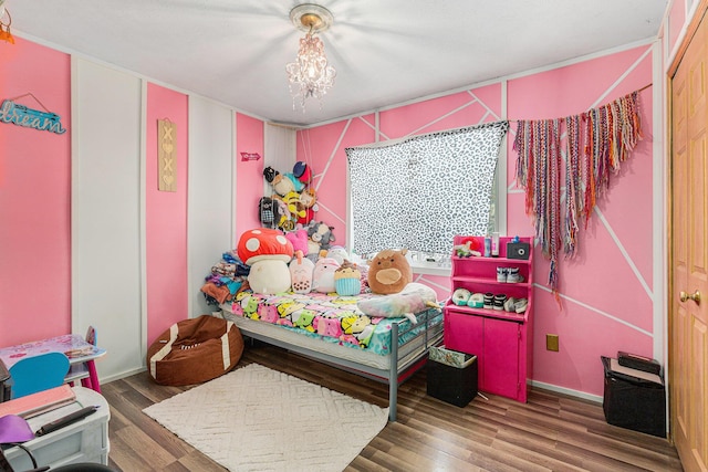 bedroom with hardwood / wood-style flooring and a chandelier