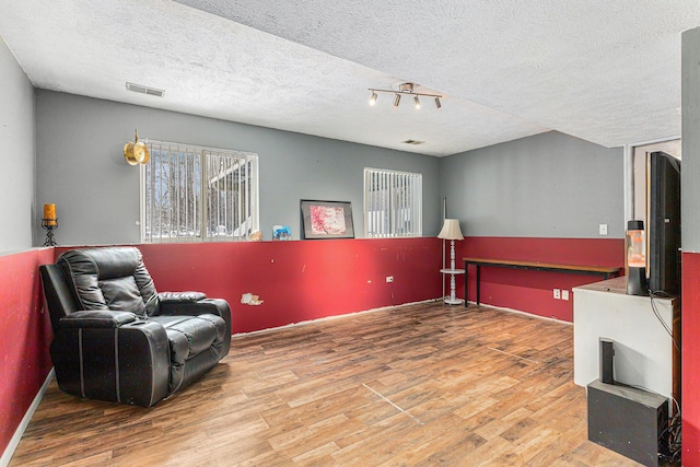 living area featuring hardwood / wood-style floors and a textured ceiling