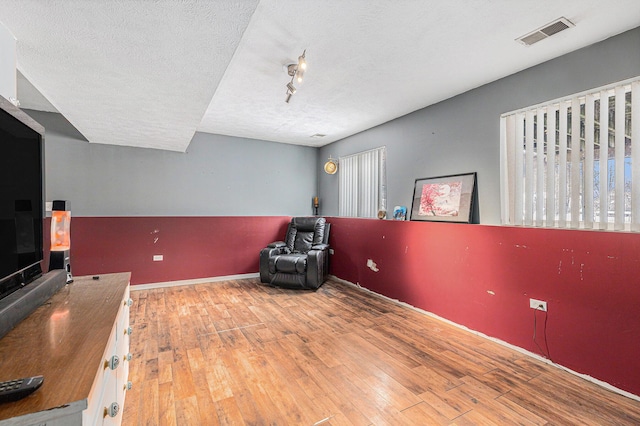 sitting room featuring hardwood / wood-style flooring and a textured ceiling