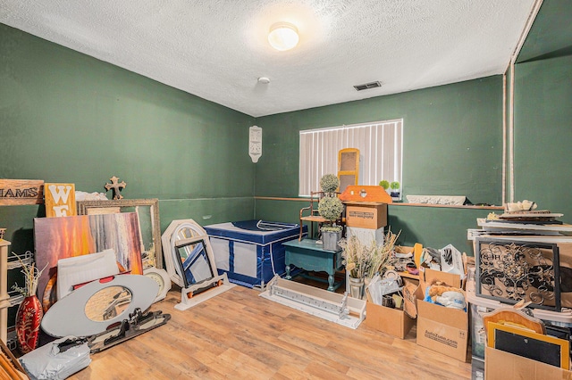 game room with hardwood / wood-style flooring and a textured ceiling