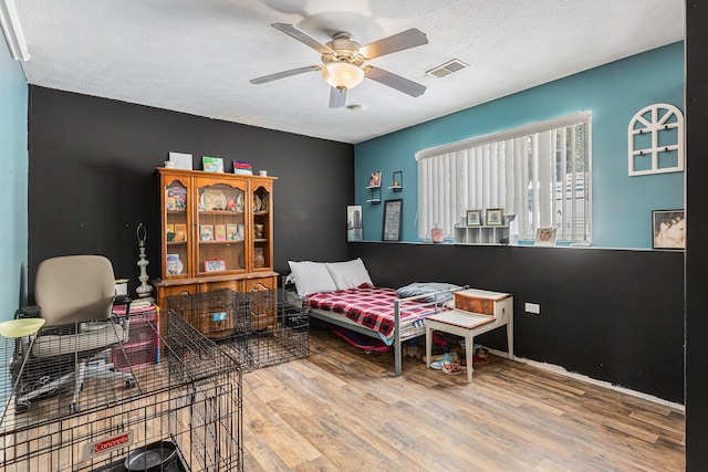 interior space featuring hardwood / wood-style floors, a textured ceiling, and ceiling fan