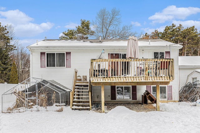 snow covered house featuring a wooden deck