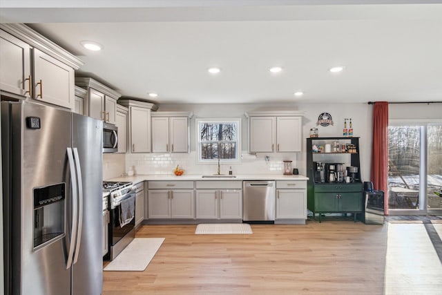 kitchen featuring stainless steel appliances, a healthy amount of sunlight, sink, and gray cabinetry