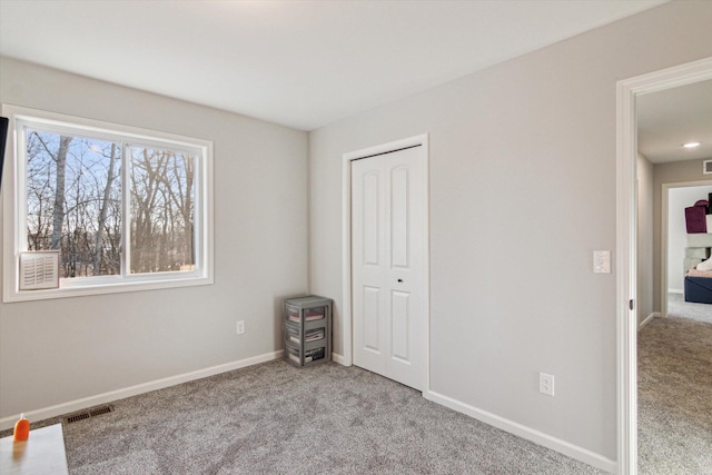 unfurnished bedroom with light colored carpet and a closet