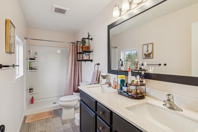 bathroom featuring vanity, hardwood / wood-style flooring, toilet, and walk in shower