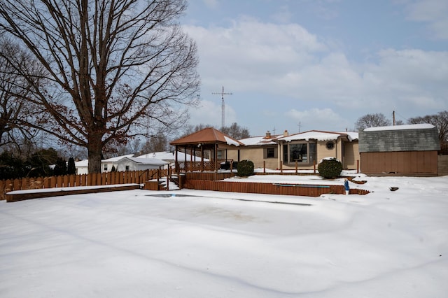 snow covered back of property with a shed