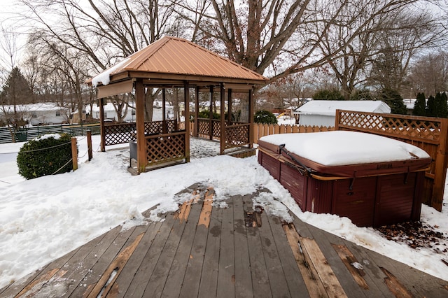 snow covered deck featuring a gazebo and a hot tub