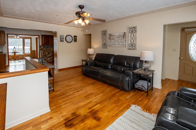 living room with light hardwood / wood-style flooring and ceiling fan