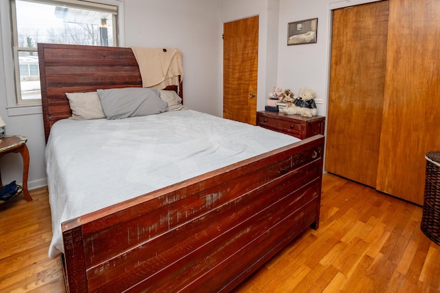 bedroom with light hardwood / wood-style floors and a closet