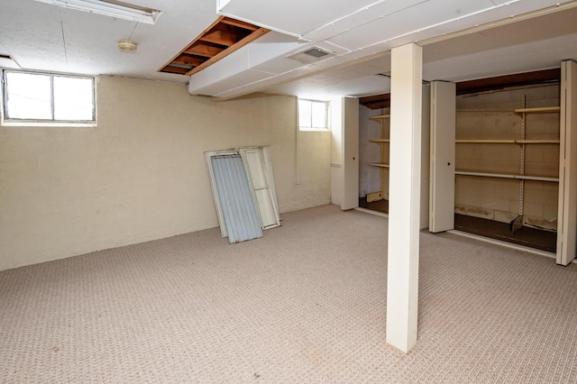 basement featuring plenty of natural light and light colored carpet