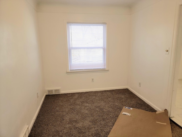 unfurnished room featuring dark carpet