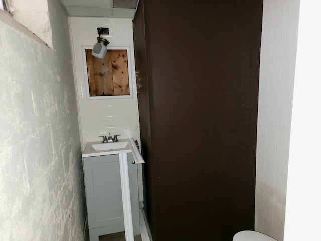 bathroom with vanity and tile walls