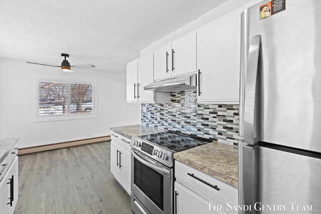 kitchen with baseboard heating, stainless steel appliances, backsplash, and white cabinets