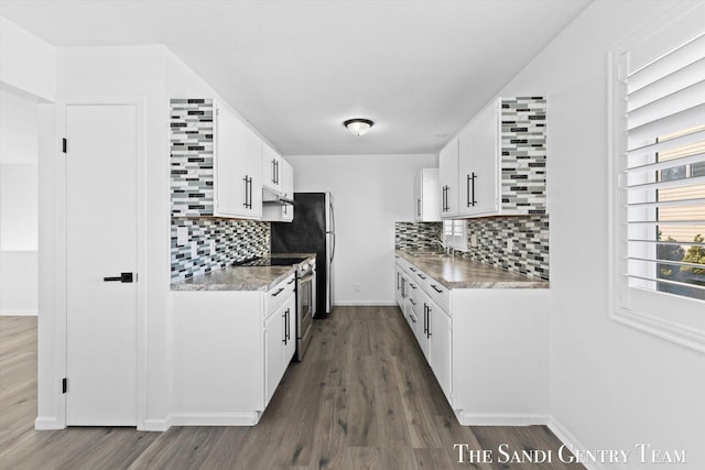 kitchen with dark wood-type flooring, sink, stainless steel electric range oven, white cabinets, and backsplash