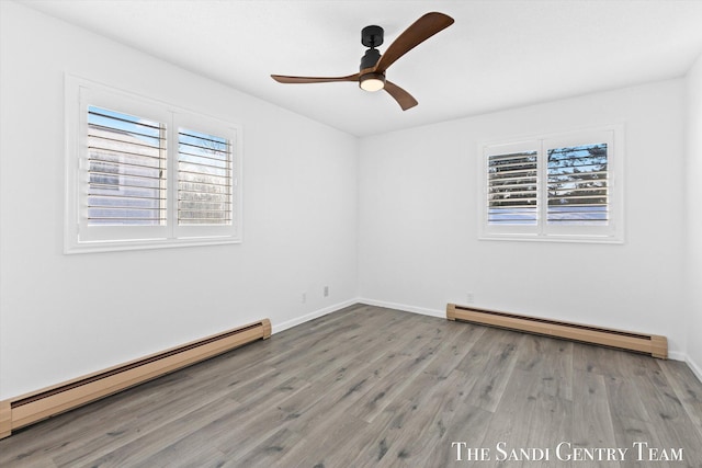 unfurnished room with a wealth of natural light, hardwood / wood-style floors, and a baseboard heating unit