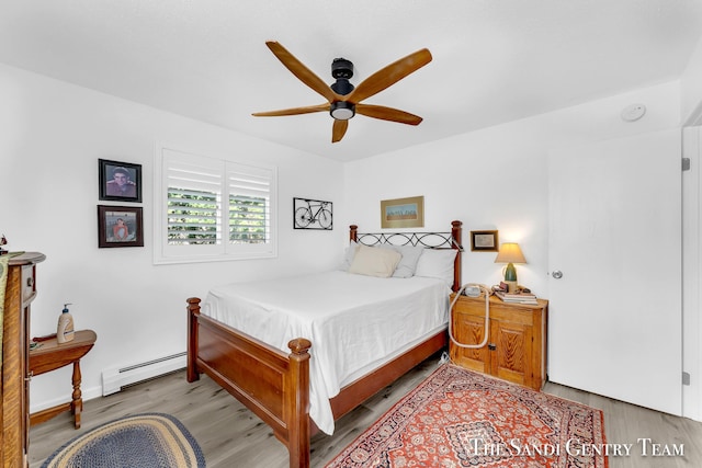 bedroom with a baseboard heating unit, light hardwood / wood-style flooring, and ceiling fan