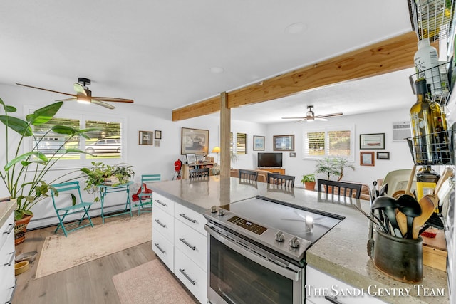 kitchen with baseboard heating, stainless steel range with electric stovetop, light stone countertops, light hardwood / wood-style floors, and white cabinets