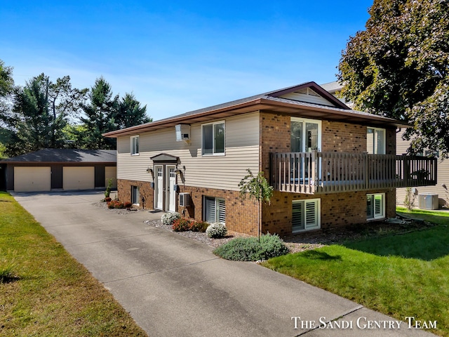 view of front of property featuring central AC, a garage, an outdoor structure, and a front lawn