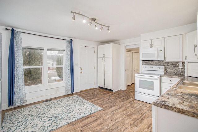 kitchen with white appliances, wood-type flooring, decorative backsplash, and white cabinets