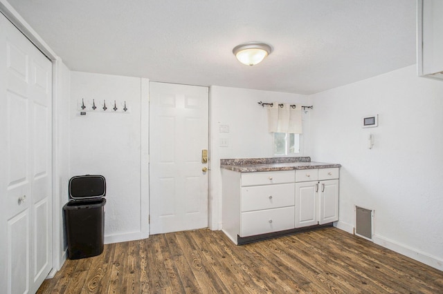 kitchen with dark hardwood / wood-style flooring and white cabinets