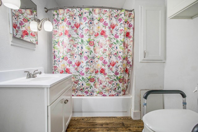 full bathroom featuring wood-type flooring, shower / bath combo, vanity, and toilet