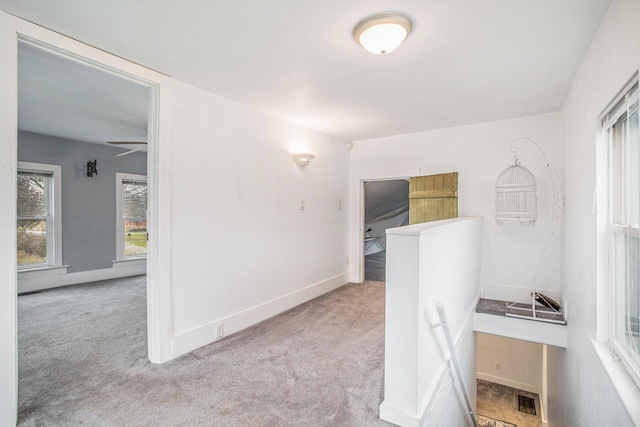 hallway featuring light colored carpet