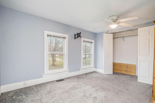 unfurnished bedroom featuring light carpet, a closet, and ceiling fan