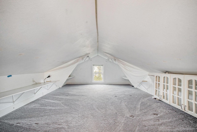 bonus room with lofted ceiling, carpet, and a textured ceiling