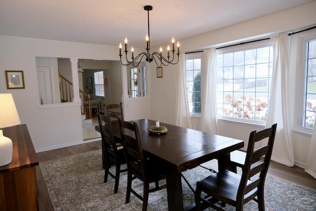 dining room with dark hardwood / wood-style flooring, a chandelier, and a textured ceiling