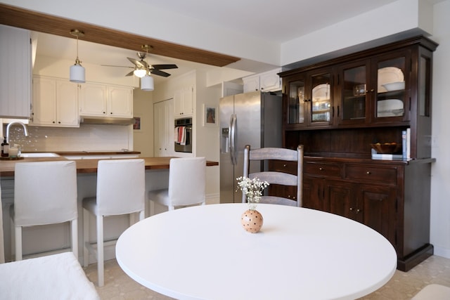 dining space featuring sink and ceiling fan