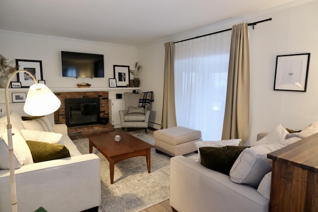 living room featuring baseboard heating, ornamental molding, a brick fireplace, and hardwood / wood-style flooring