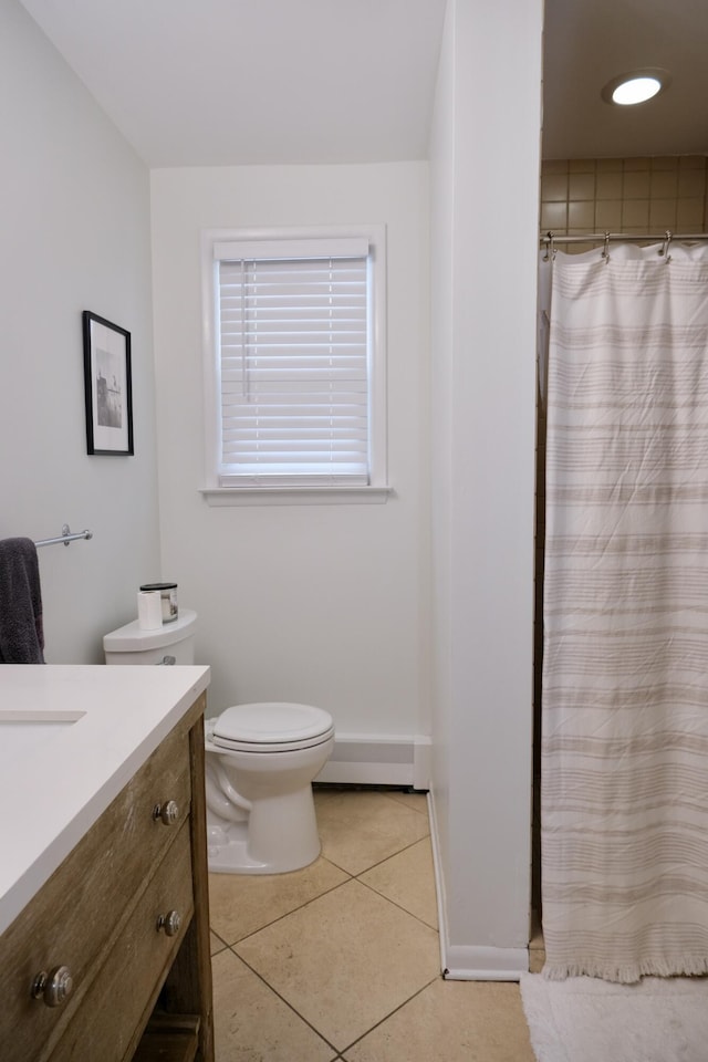 bathroom featuring baseboard heating, tile patterned flooring, vanity, toilet, and walk in shower