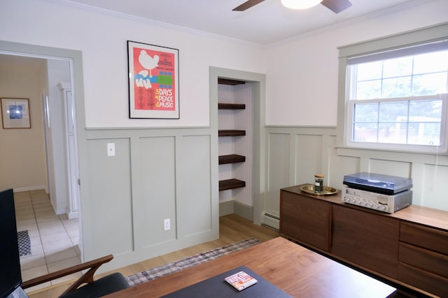 office space featuring crown molding, a baseboard radiator, ceiling fan, and light wood-type flooring