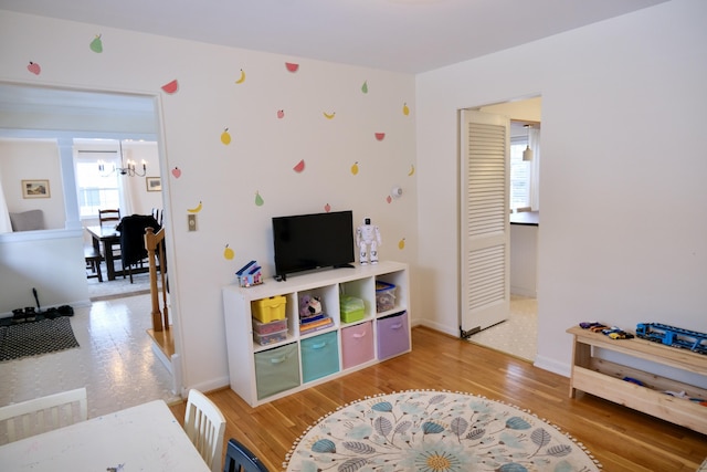 playroom with an inviting chandelier and light hardwood / wood-style floors