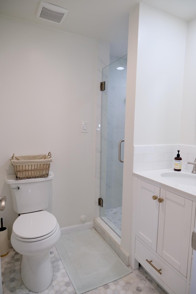 bathroom with vanity, tile patterned floors, toilet, and walk in shower