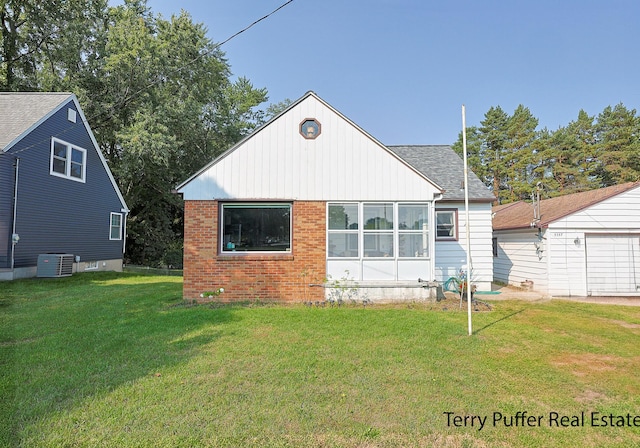 rear view of house featuring cooling unit and a yard