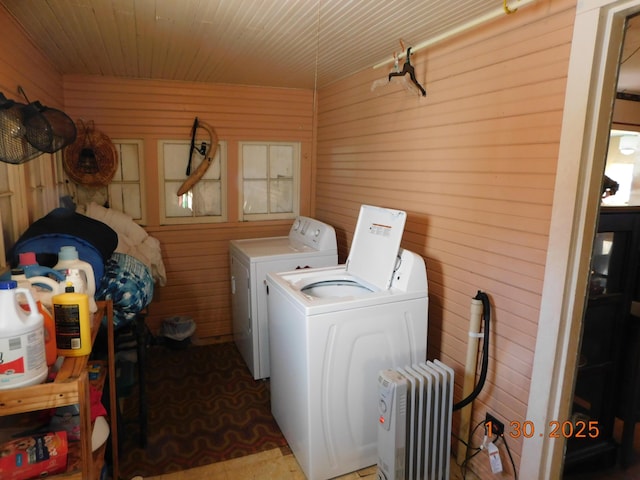 washroom with radiator, wooden walls, and washer and clothes dryer