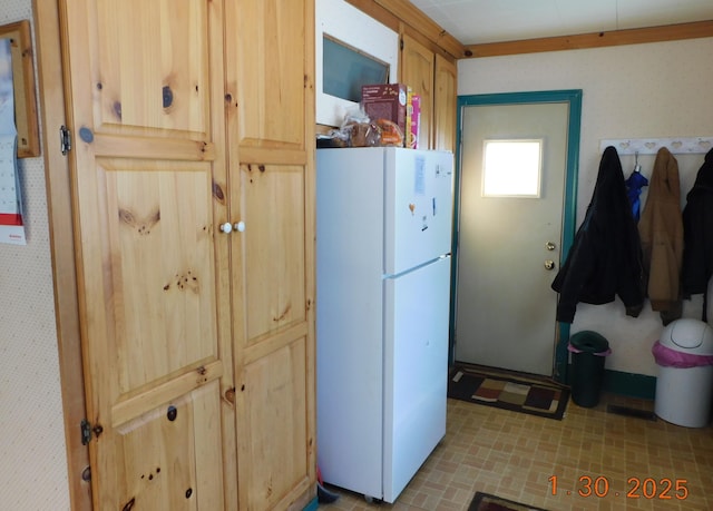 kitchen featuring light brown cabinets and white fridge