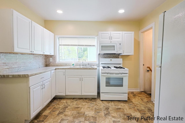 kitchen featuring sink, white appliances, decorative backsplash, and white cabinets