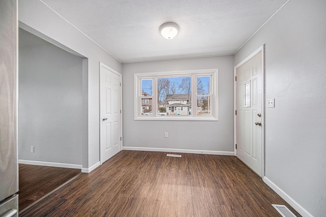 foyer featuring dark hardwood / wood-style floors and a textured ceiling