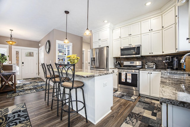 kitchen with sink, decorative light fixtures, white cabinets, and appliances with stainless steel finishes