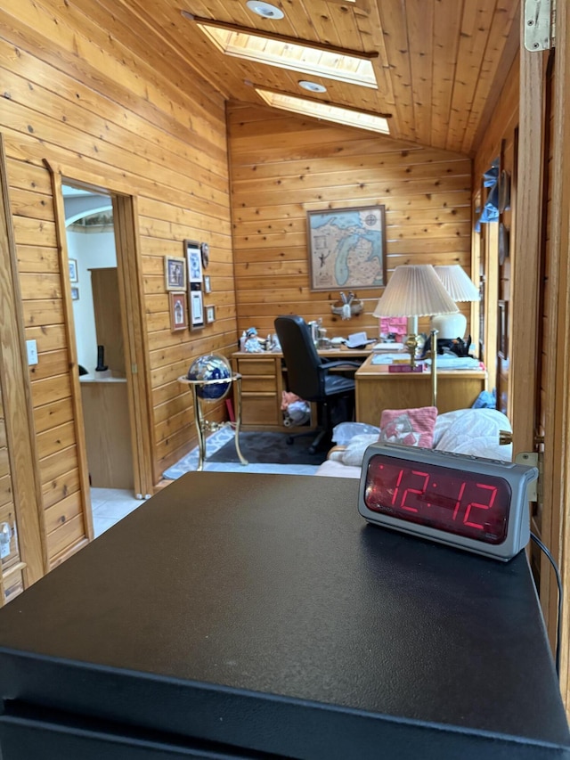 office with wood ceiling, wooden walls, and lofted ceiling with skylight