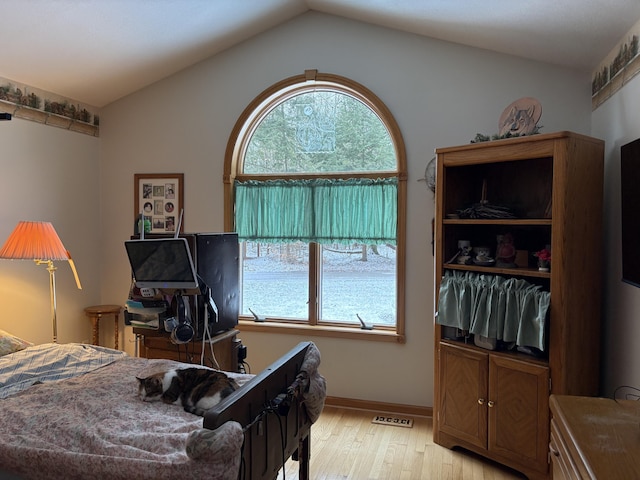 bedroom with lofted ceiling and light hardwood / wood-style floors