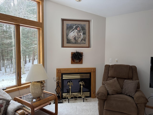 living area featuring light carpet, a fireplace, and lofted ceiling